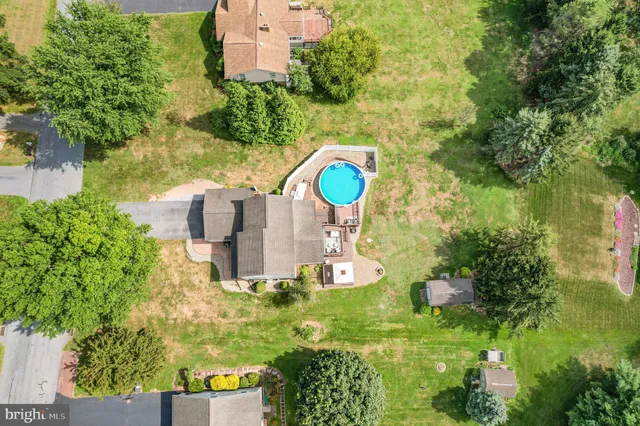a aerial view of a house with a yard and large trees