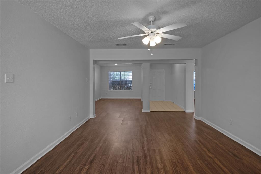 2910 Chisholm Trail Corinth, TX 76210 - Photo 7 of 30 a view of an empty room with wooden floor and a window