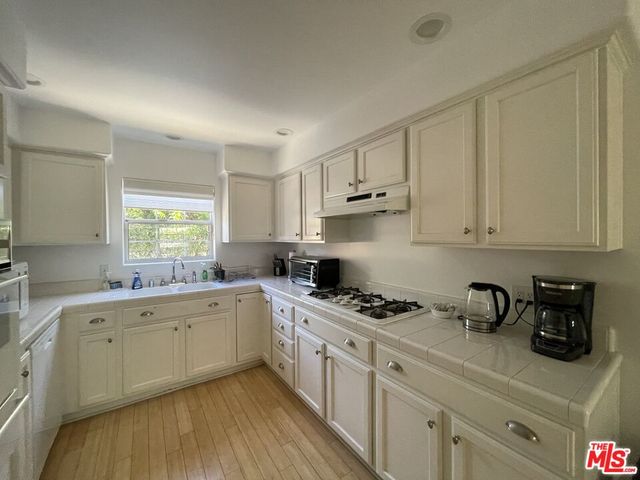 a kitchen with a refrigerator a stove a sink and a window
