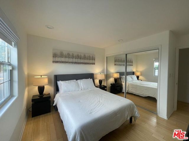 a bedroom with a bed and a dresser next to a window