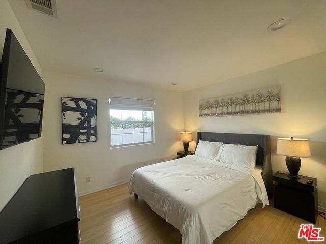 a bedroom with a bed and wooden floor