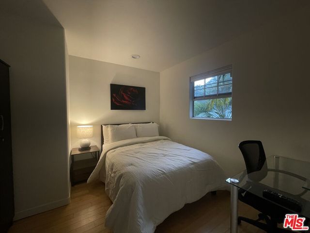 a bedroom with a bed and wooden floor