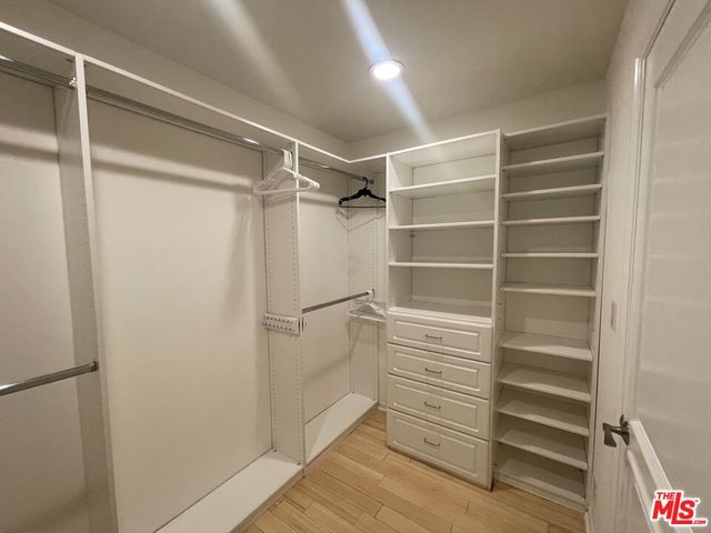 a spacious bedroom with a bed and a flat screen tv