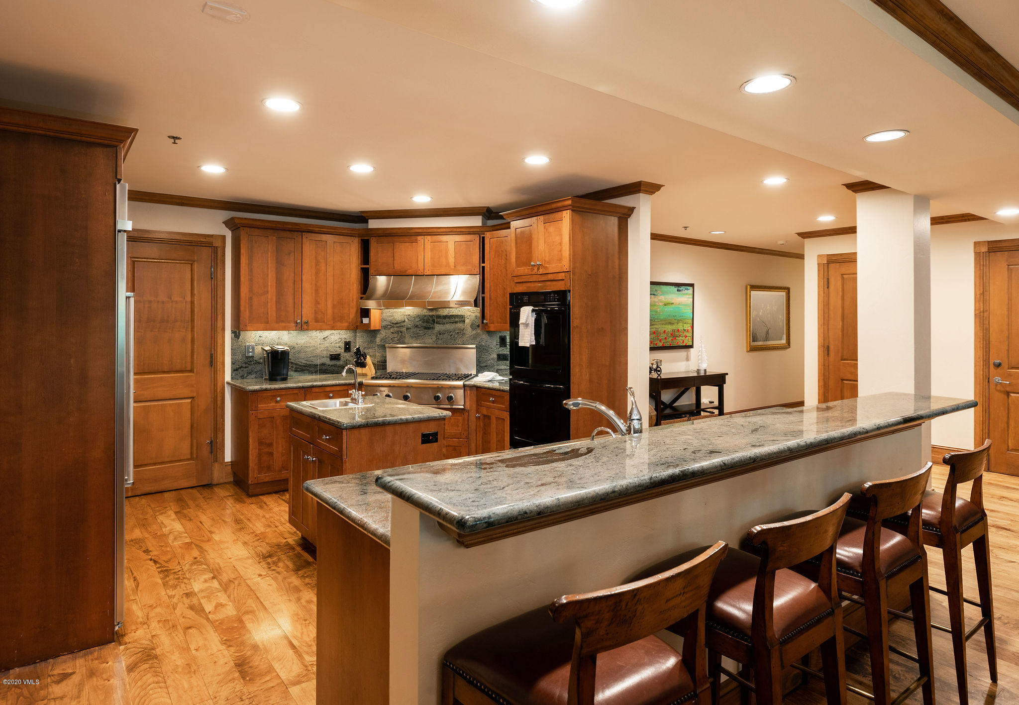 62 Highlands Lane, Unit R602 Beaver Creek, CO 81620 - Photo 8 of 30 a kitchen with kitchen island granite countertop wooden cabinets and refrigerator