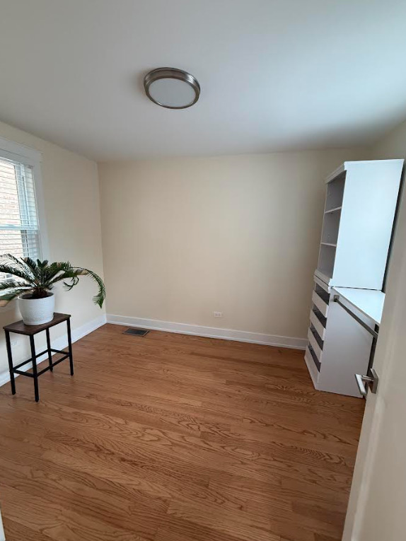 6014 West Fletcher Street Chicago, IL 60634 - Photo 2 of 3 a view of an empty room and window and wooden floor
