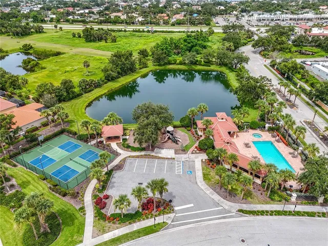 an aerial view of residential houses with outdoor space and lake view