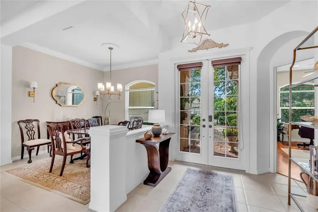 a living room with furniture a chandelier and a dining table