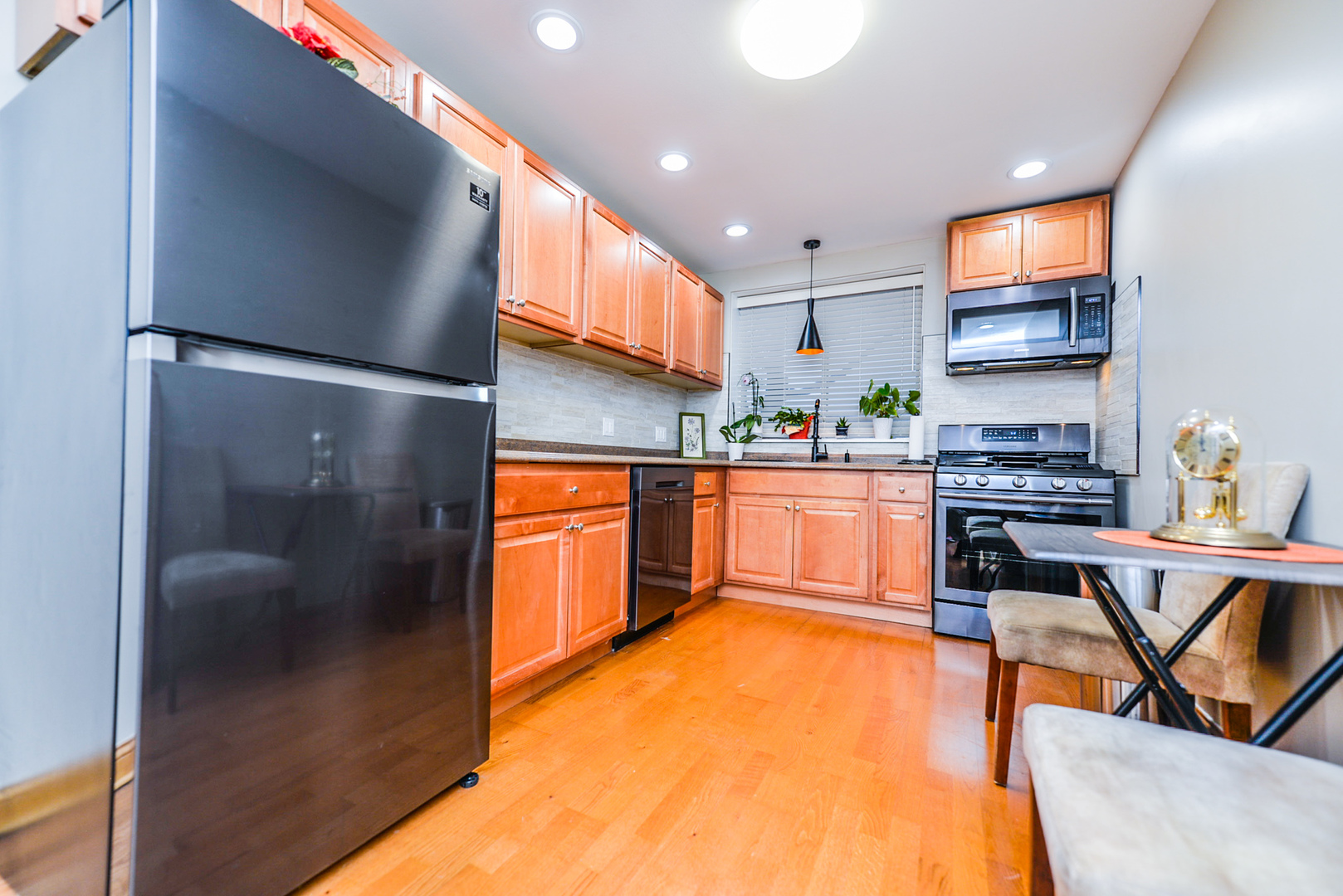 280 North Westgate Road, Unit 128 Mount Prospect, IL 60056 - Photo 7 of 29 a kitchen with stainless steel appliances granite countertop a refrigerator a sink a stove and a dining table with wooden floor