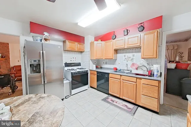 a kitchen with granite countertop a refrigerator sink stove and oven