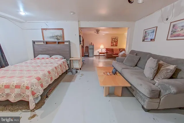 a bedroom with a bed a couch and dresser