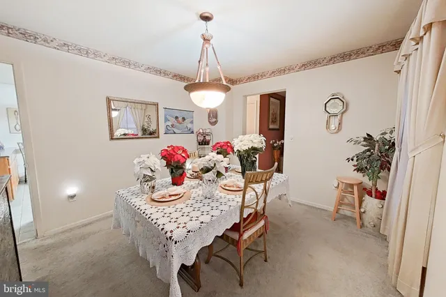 a dining room with furniture a chandelier and window