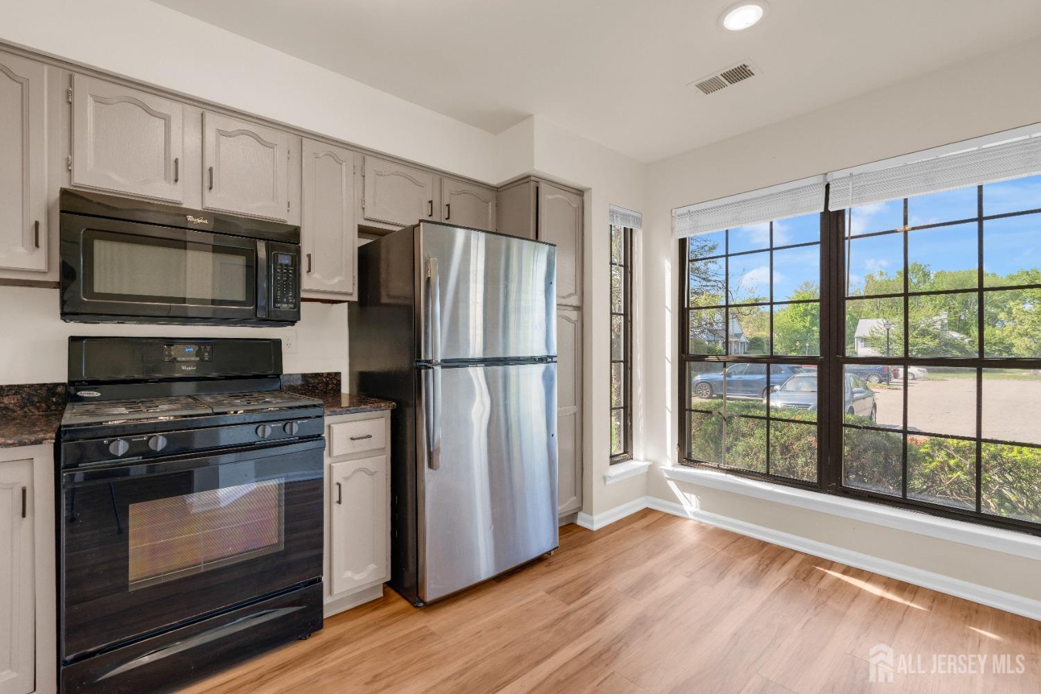 1405 Maplecrest Road Edison, NJ 08820 - Photo 11 of 33 a kitchen with granite countertop wooden cabinets stainless steel appliances and a window