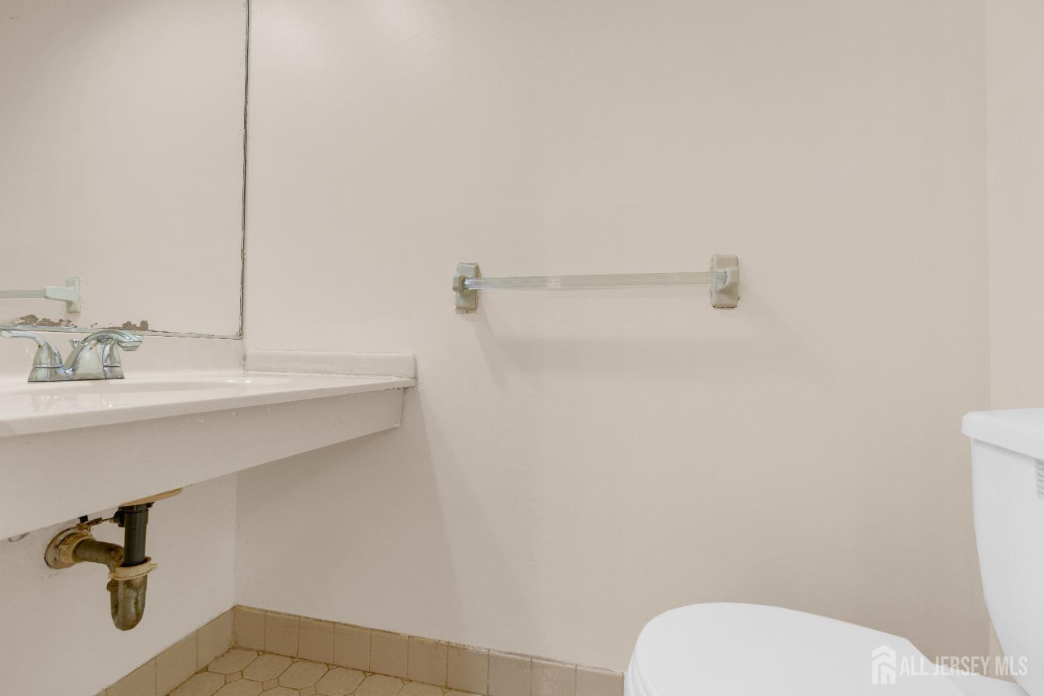 1405 Maplecrest Road Edison, NJ 08820 - Photo 19 of 33 a bathroom with a sink a toilet and a mirror