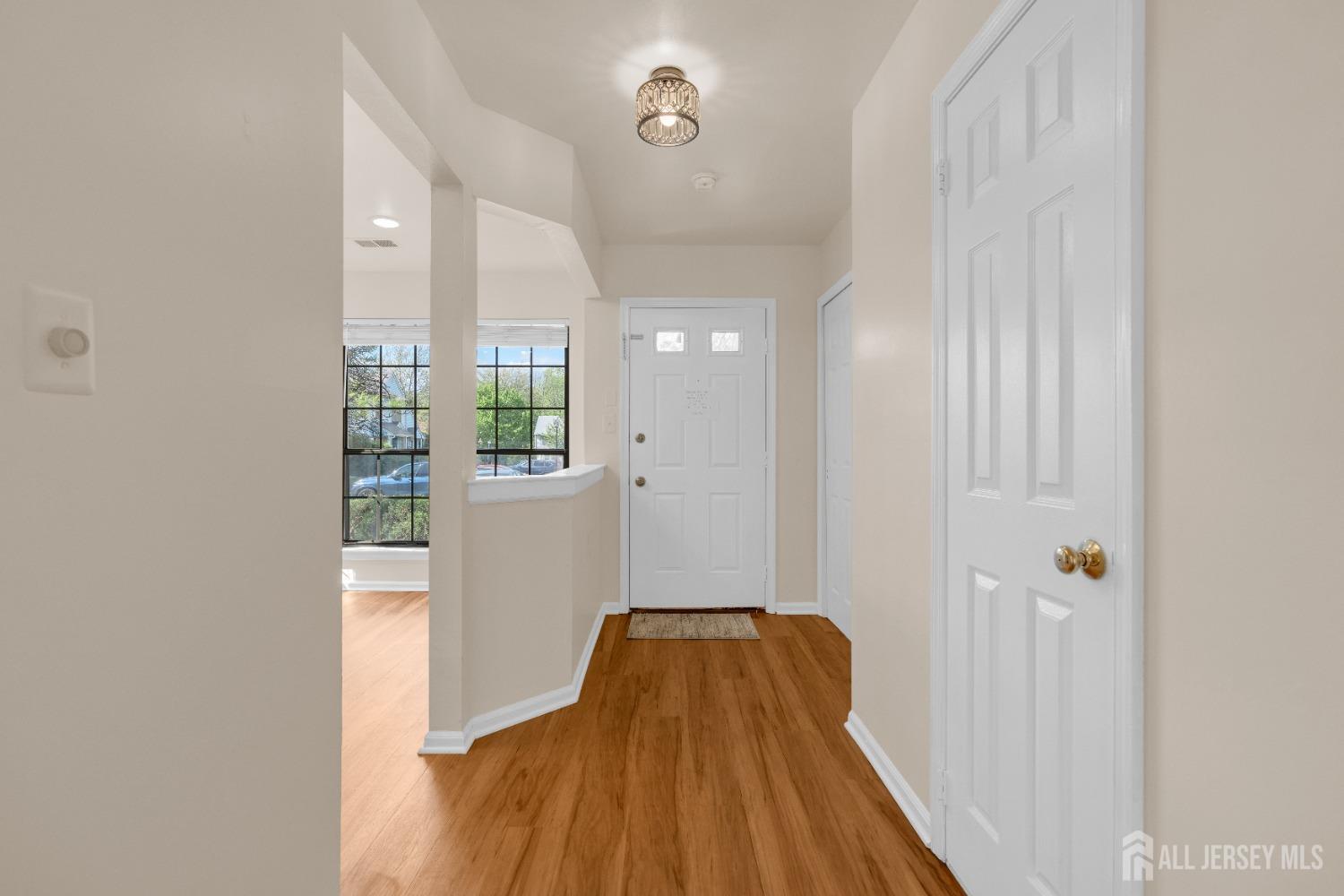 1405 Maplecrest Road Edison, NJ 08820 - Photo 5 of 33 a view of a hallway with wooden floor and a bathroom