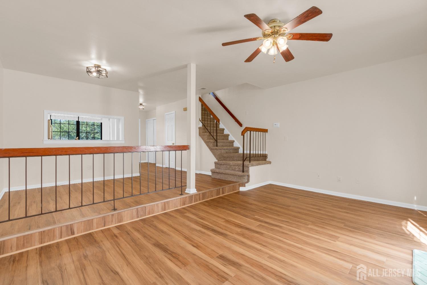 1405 Maplecrest Road Edison, NJ 08820 - Photo 9 of 33 an empty room with wooden floor fan and windows