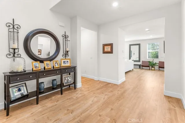 a living room with furniture a mirror and a wooden floor