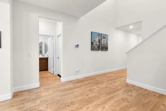 a view of a hallway with wooden floor and a kitchen