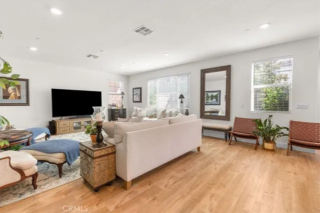 a living room with furniture a flat screen tv and a large window