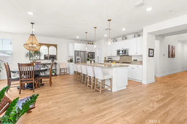 a kitchen with stainless steel appliances kitchen island granite countertop a table and chairs in it