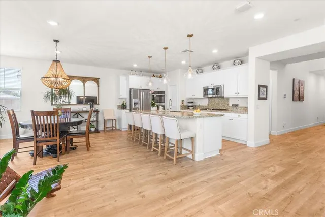 a kitchen with stainless steel appliances kitchen island granite countertop a table and chairs in it