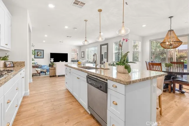 a large kitchen with kitchen island a large counter top a sink appliances and cabinets