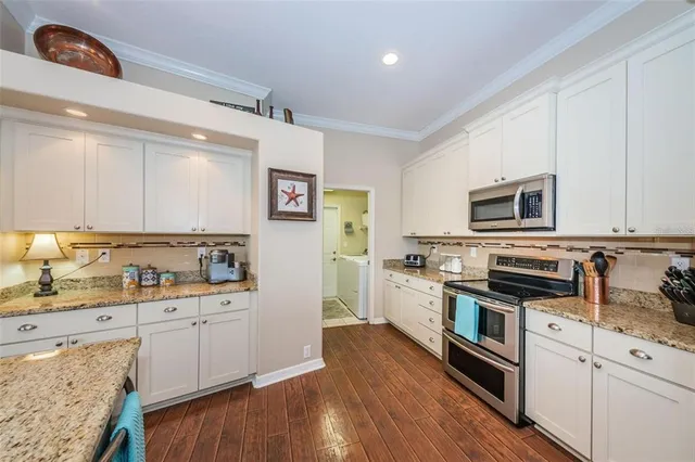 a kitchen with stainless steel appliances a stove refrigerator sink and microwave