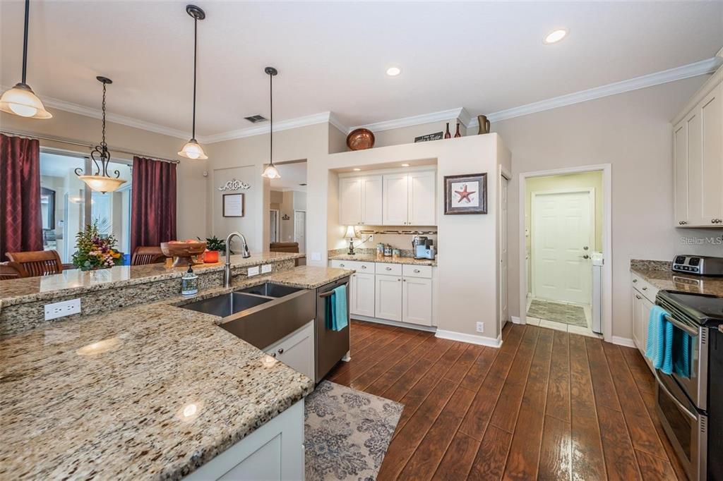 1203 Hagen Drive Trinity, FL 34655 - Photo 10 of 21 a large kitchen with kitchen island a stove a sink a refrigerator and wooden floor