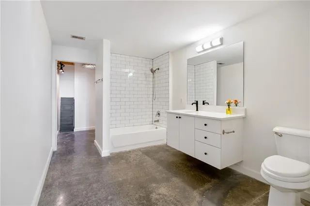 a bathroom with a double vanity sink toilet mirror and bathtub
