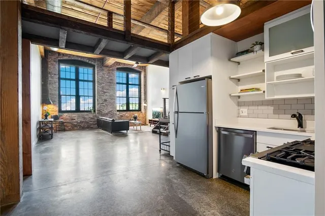 a kitchen with refrigerator a stove and a wooden floors