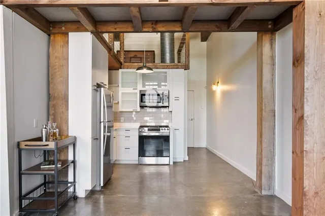a view of a kitchen with a refrigerator and a stove top oven