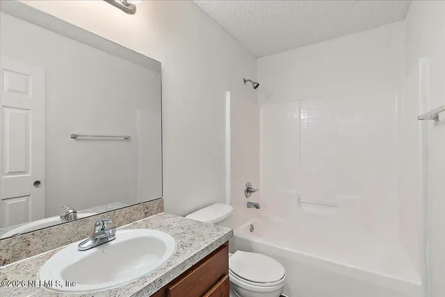 a bathroom with a granite countertop sink toilet a mirror and shower