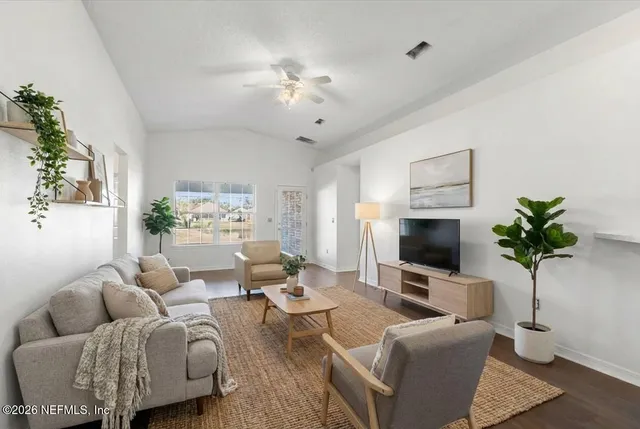a living room with furniture a chandelier and a flat screen tv