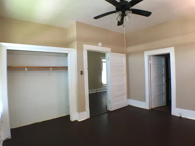 a view of empty room with wooden floor