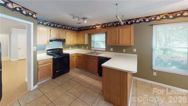 a kitchen with a sink a stove top oven a refrigerator and a window