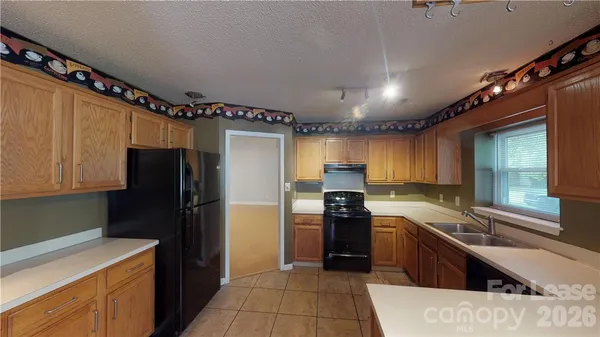 a kitchen with granite countertop a refrigerator and a sink