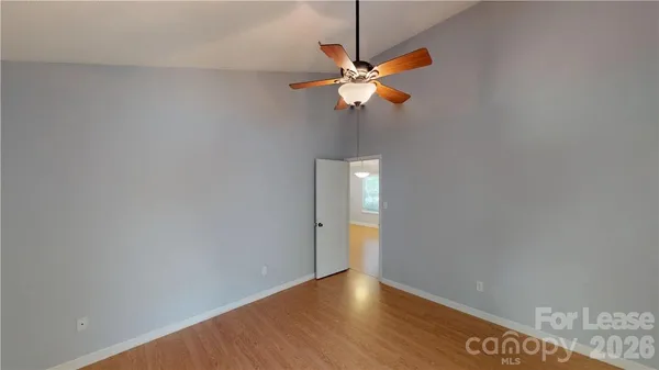 a view of a room with wooden floor and fan