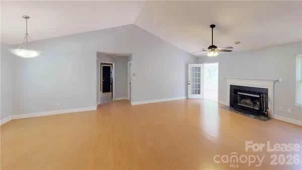 a view of an empty room with a fireplace and a window