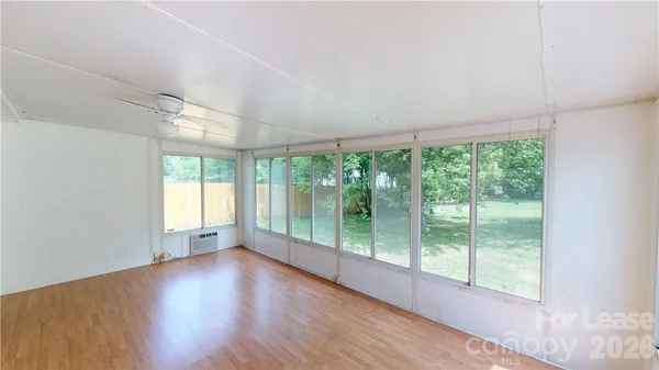 a view of a big room with windows and chandelier fan
