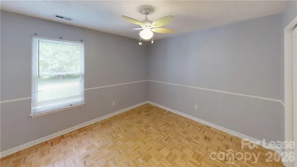 an empty room with a window and a ceiling fan