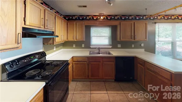 a kitchen with granite countertop a stove a sink and a cabinets