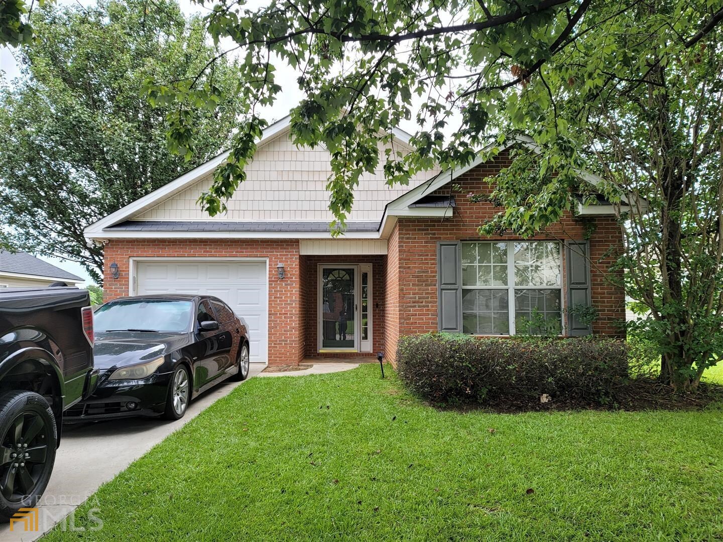 a front view of a house with a garden and garage