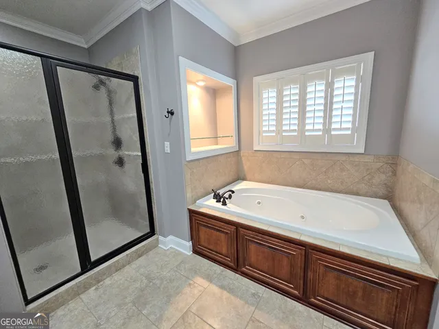 a bathroom with a tub sink shower and a mirror