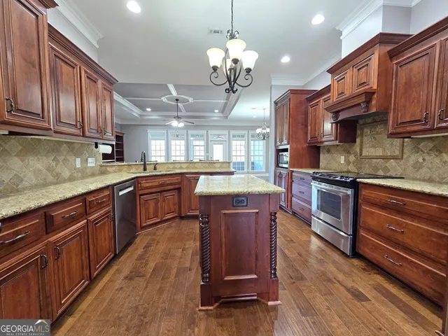 a kitchen with stainless steel appliances granite countertop wooden floors and wooden cabinets