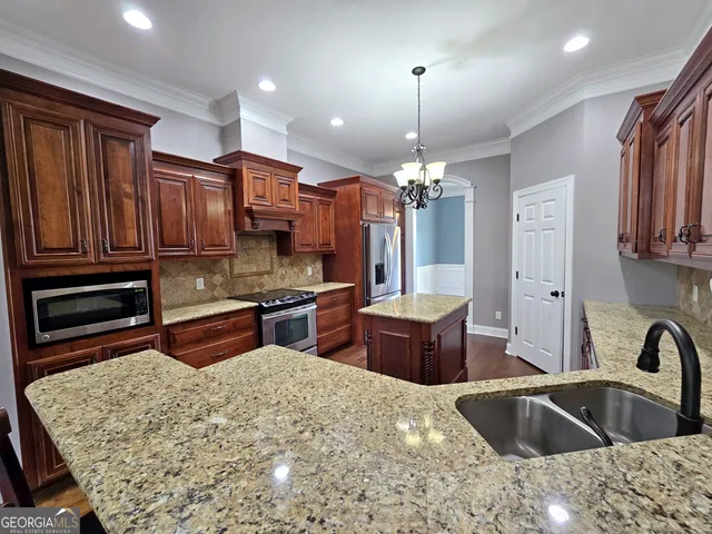 a kitchen with stainless steel appliances granite countertop a sink refrigerator and cabinets