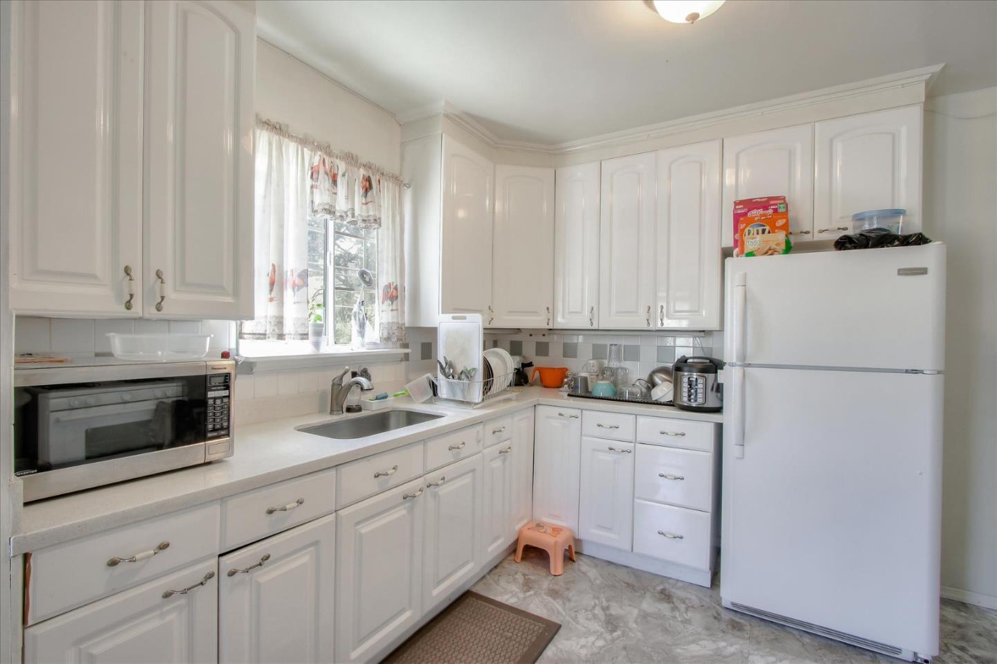 Willits Street Daly City, CA 94014 - Photo 14 of 50 a kitchen with cabinets appliances a sink and a window
