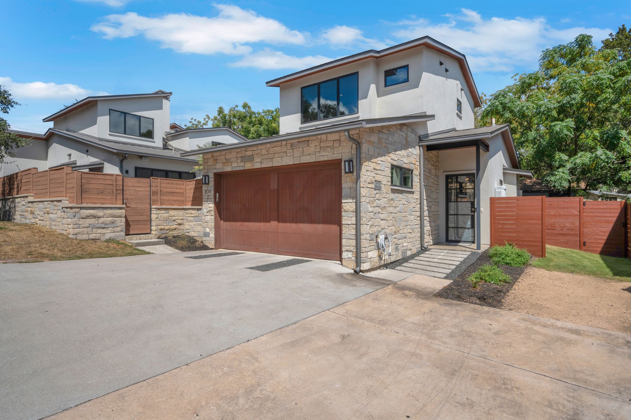 809 Bouldin Avenue Austin, TX 78704 - Photo 27 of 39 Contemporary house with concrete driveway, stucco siding, a gate, a garage, and stone siding