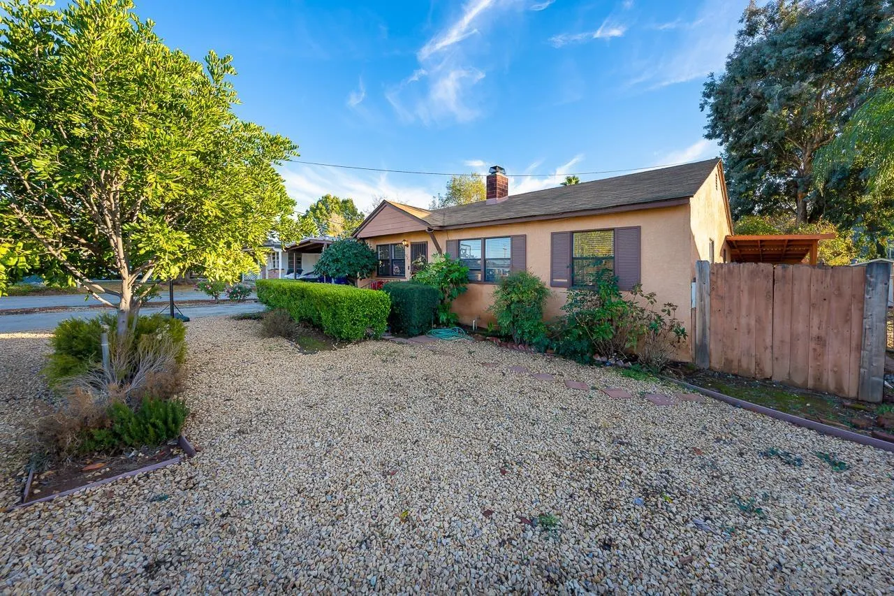 1225 Andover Road El Cajon, CA 92019 - Photo 4 of 27 a view of a white house next to a yard with large trees