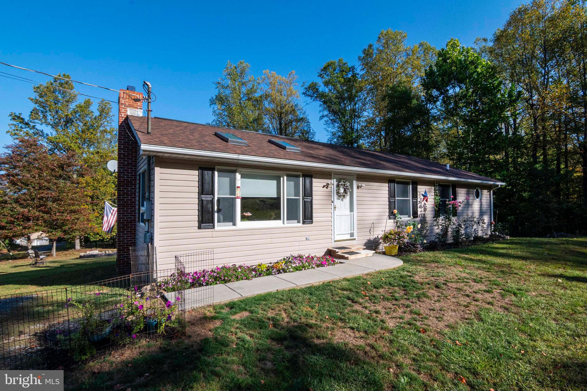 3225 Magnolia Road Great Cacapon, WV 25422 - Photo 37 of 59 a front view of house with yard outdoor seating and barbeque oven