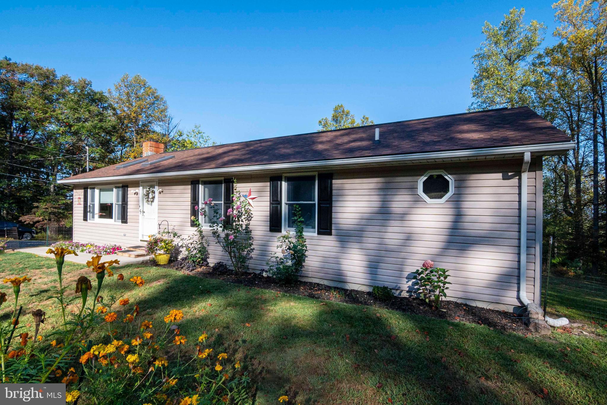 3225 Magnolia Road Great Cacapon, WV 25422 - Photo 38 of 59 a front view of a house with garden