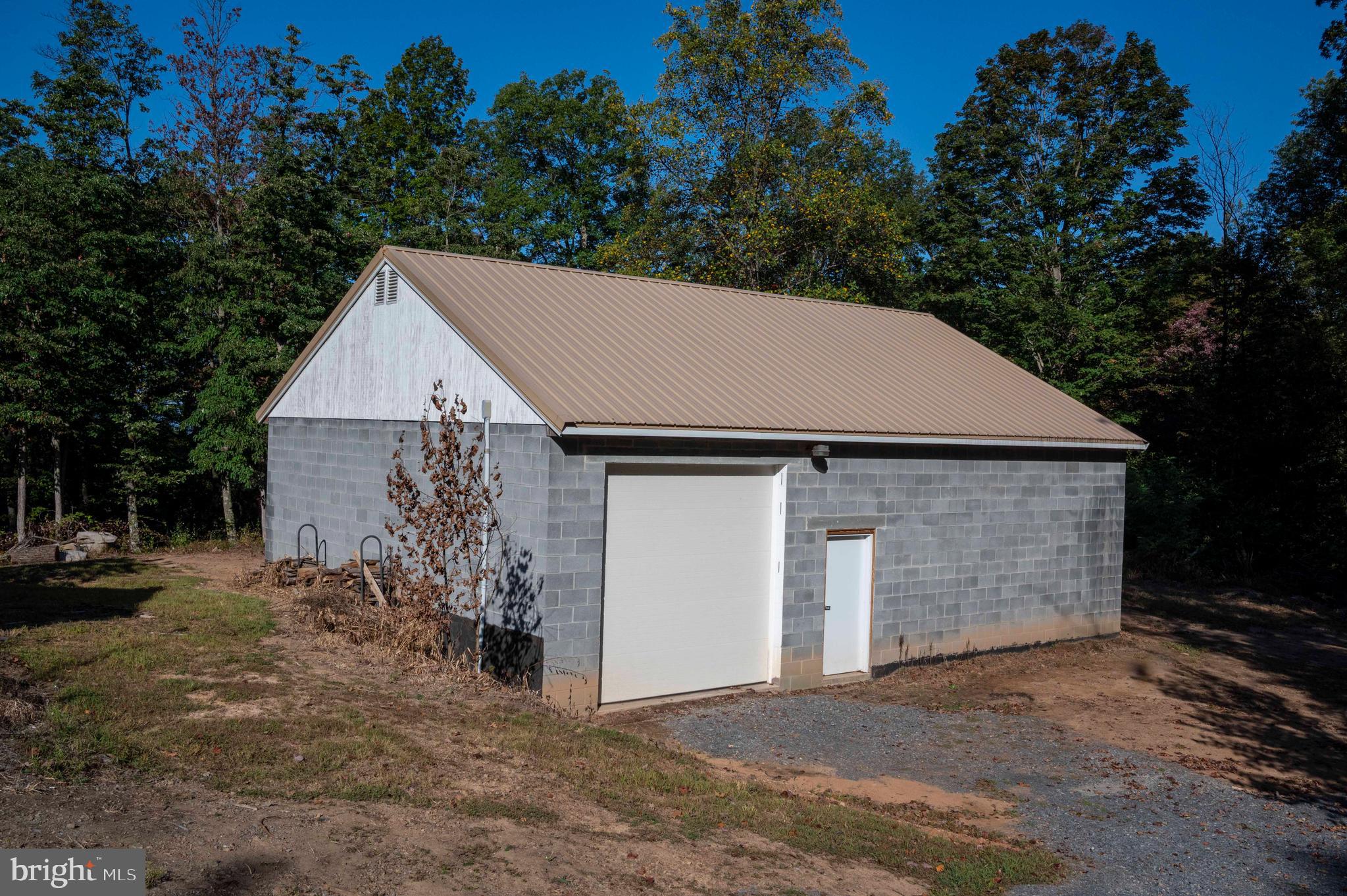 3225 Magnolia Road Great Cacapon, WV 25422 - Photo 46 of 59 a view of a house with a yard and garage